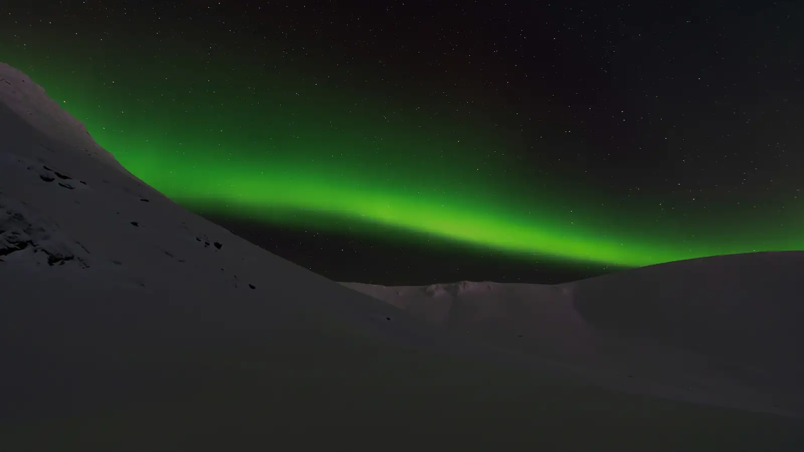雪山の上を走るオーロラ